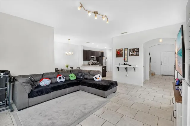 a living room with furniture flowers and a flat screen tv