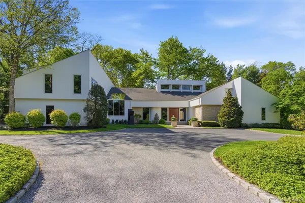 a front view of a house with a yard and trees