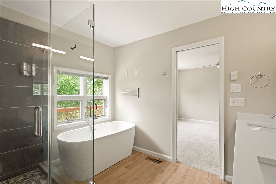 517 Willow Trail Boone, NC 28607 - Photo 9 of 26 a bathroom with a tub a sink and wooden floor