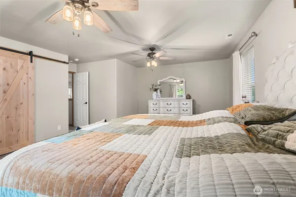 a bedroom with a large bed and a chandelier