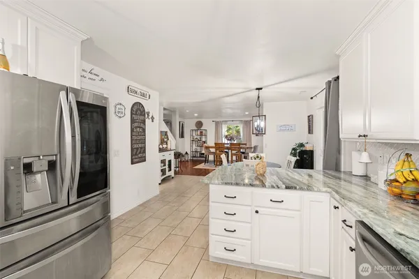 a kitchen with granite countertop a refrigerator and cabinets