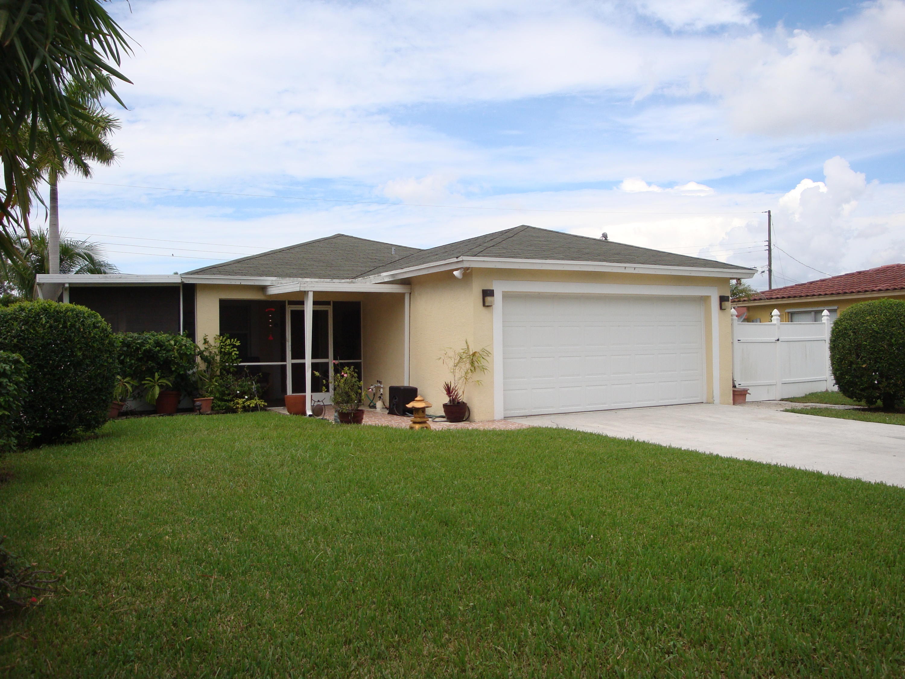 15035 Jackson Road Delray Beach, FL 33484 - Photo 1 of 17 a front view of a house with a garden and trees