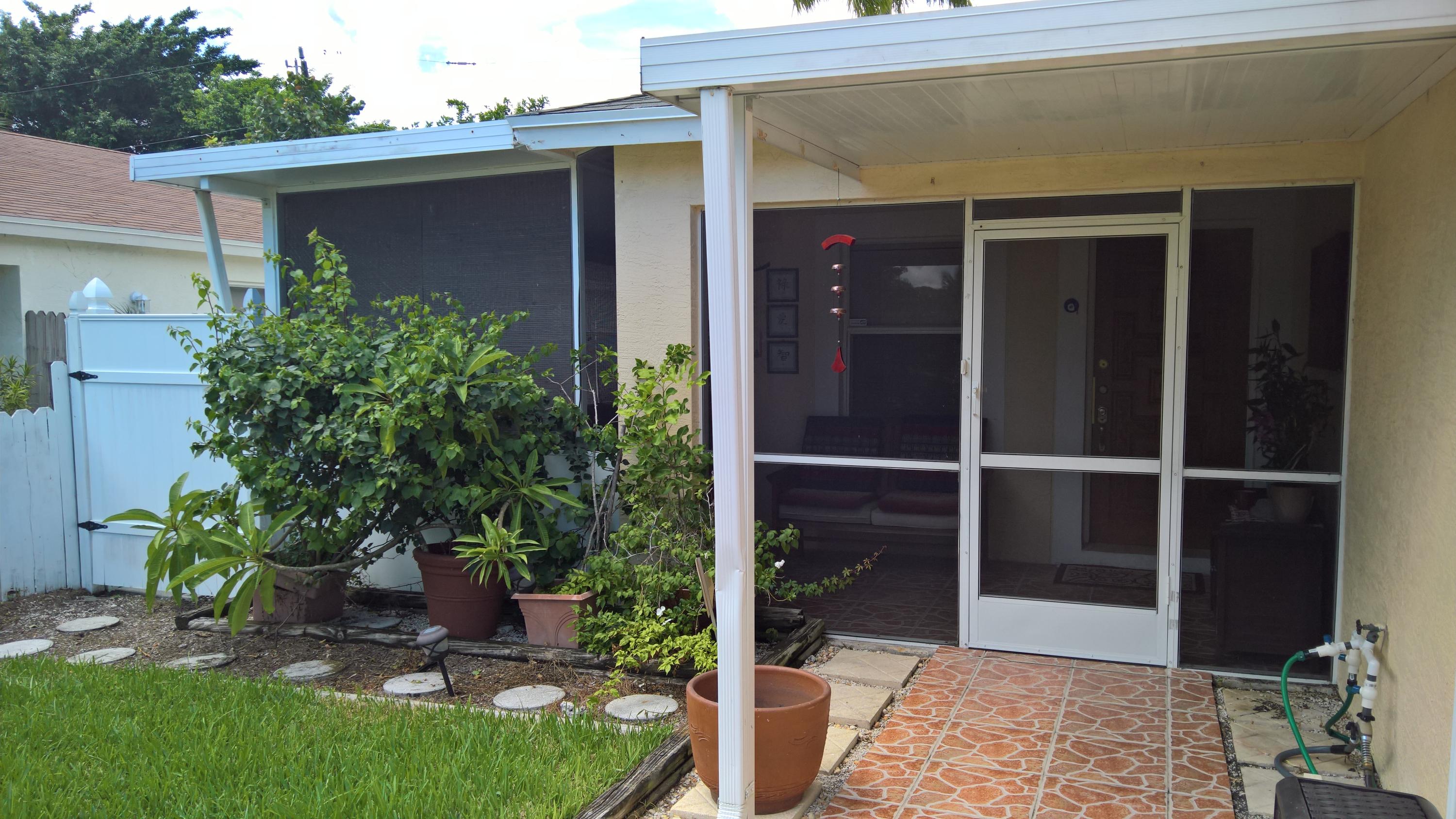 15035 Jackson Road Delray Beach, FL 33484 - Photo 12 of 17 a view of backyard with potted plants and a table