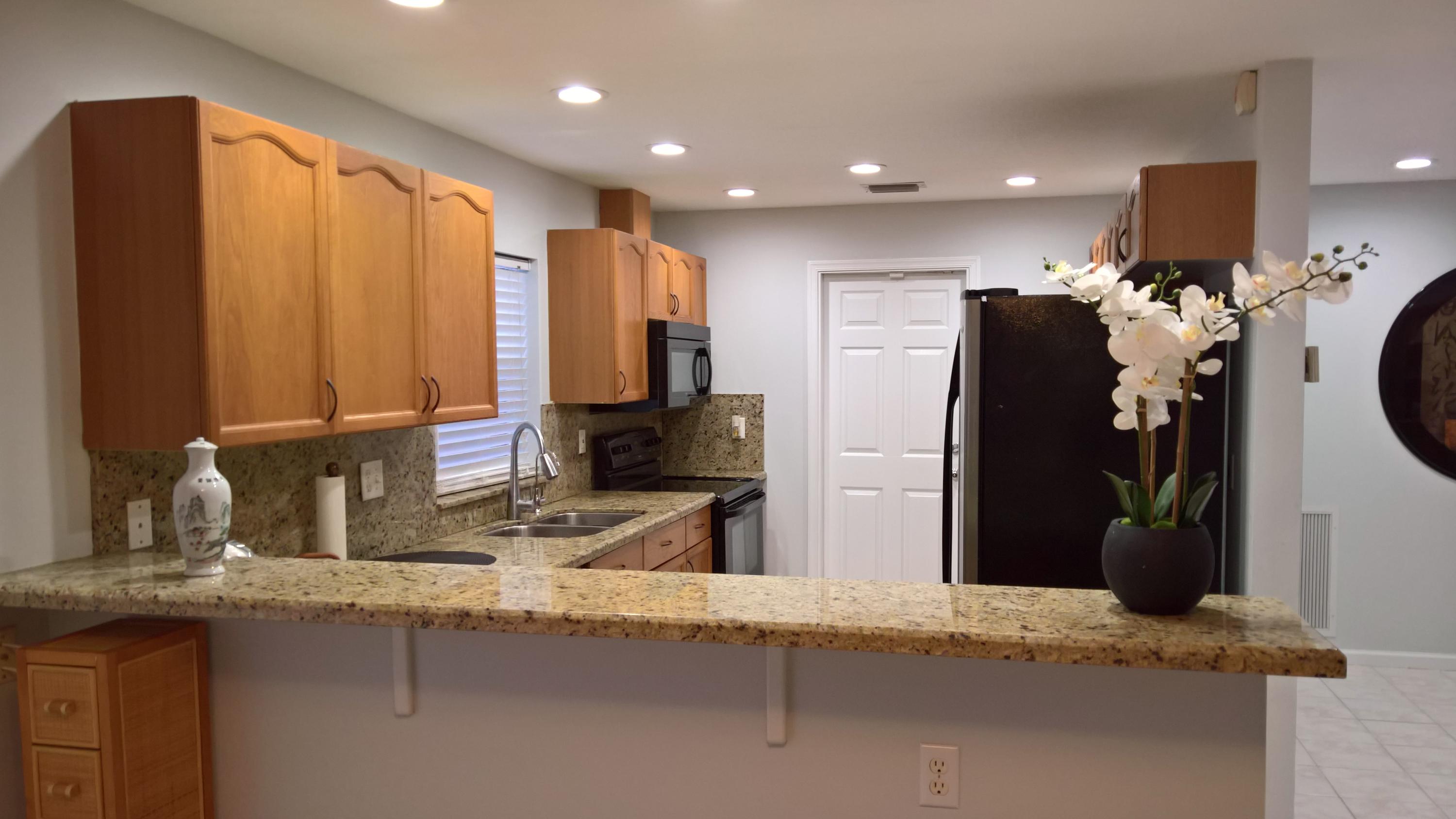 15035 Jackson Road Delray Beach, FL 33484 - Photo 4 of 17 a kitchen with a sink and a refrigerator