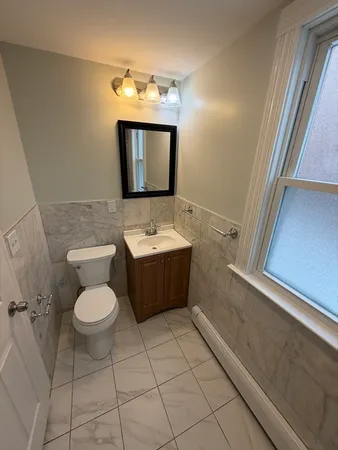 a bathroom with a toilet sink and mirror