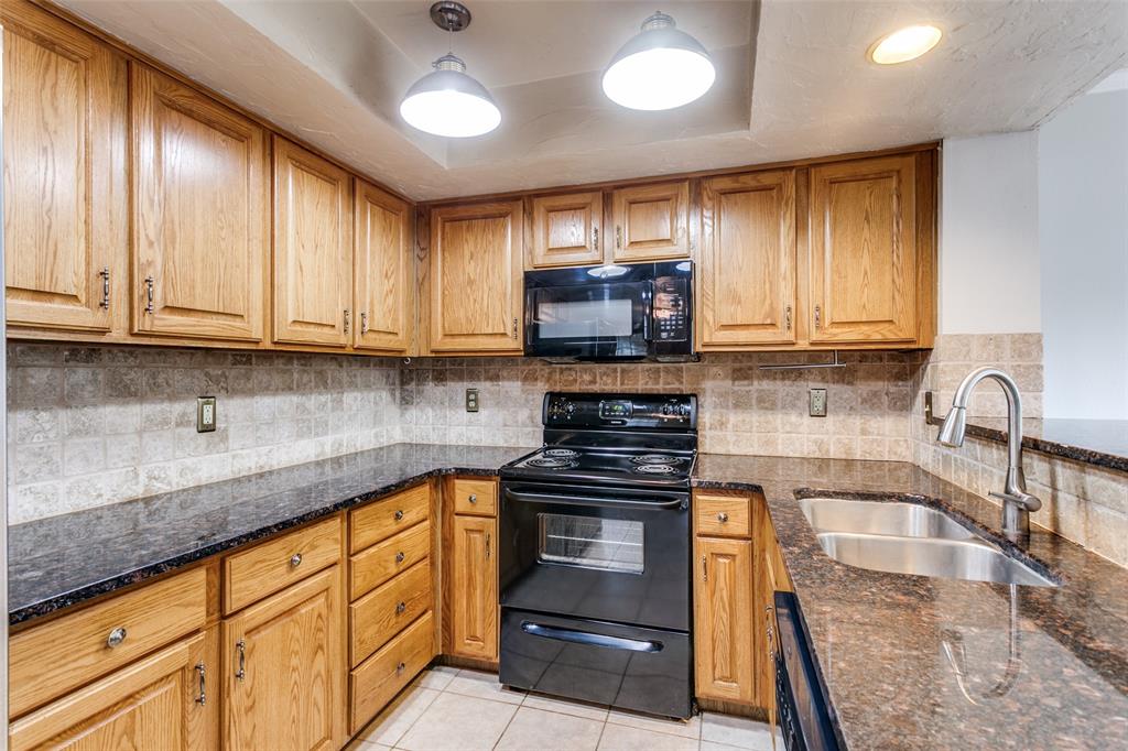 9416 Penny Lane Irving, TX 75063 - Photo 12 of 21 a kitchen with stainless steel appliances granite countertop a stove a sink and a microwave