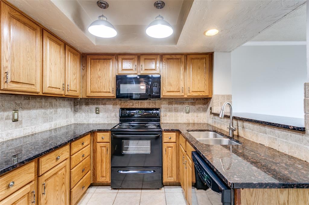 9416 Penny Lane Irving, TX 75063 - Photo 13 of 21 a kitchen with stainless steel appliances granite countertop a sink stove and cabinets