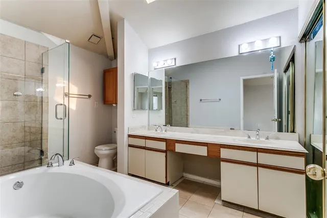 a bathroom with a bathtub shower sink mirror and toilet