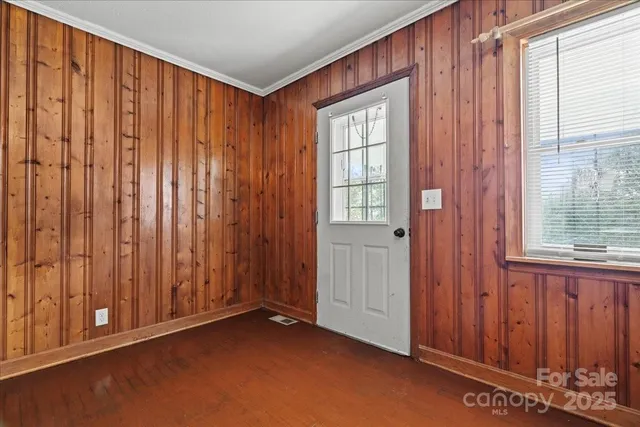an empty room with windows wooden walls