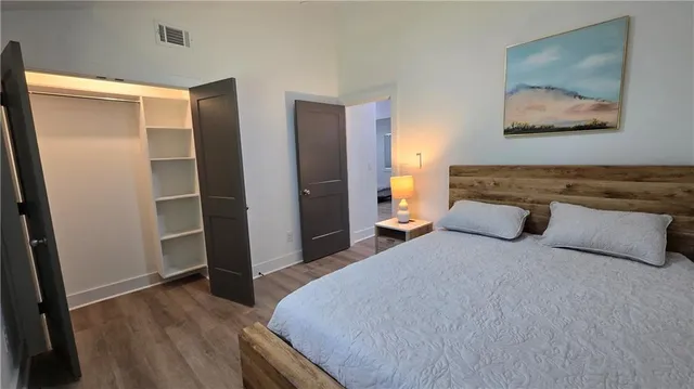 a bedroom with a bed and a refrigerator