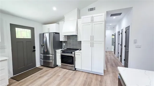 a kitchen with stainless steel appliances a refrigerator sink and stove