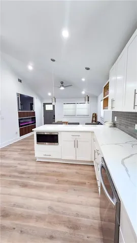 a large white kitchen with kitchen island a sink a stove and a refrigerator