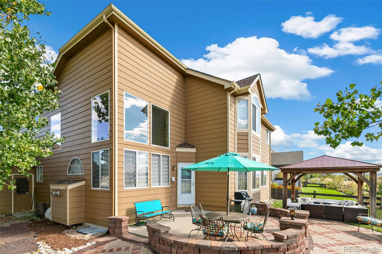 10275 Baneberry Place Highlands Ranch, CO 80129 - Photo 35 of 50 a patio with a table and chairs under an umbrella