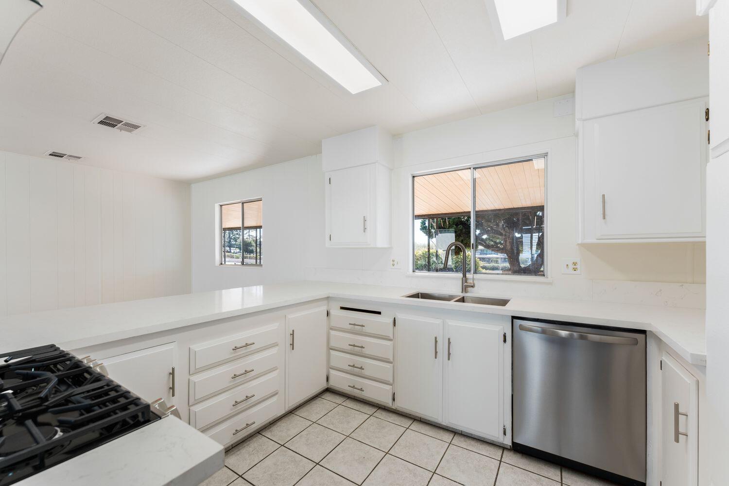 6180 Via Real, Unit 118 Carpinteria, CA 93013 - Photo 11 of 37 a kitchen with white cabinets and appliances