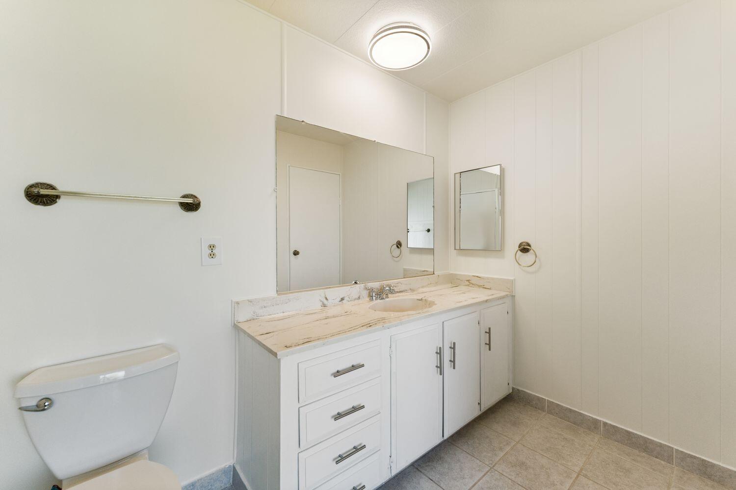 6180 Via Real, Unit 118 Carpinteria, CA 93013 - Photo 20 of 37 a spacious bathroom with a granite countertop sink mirror and toilet