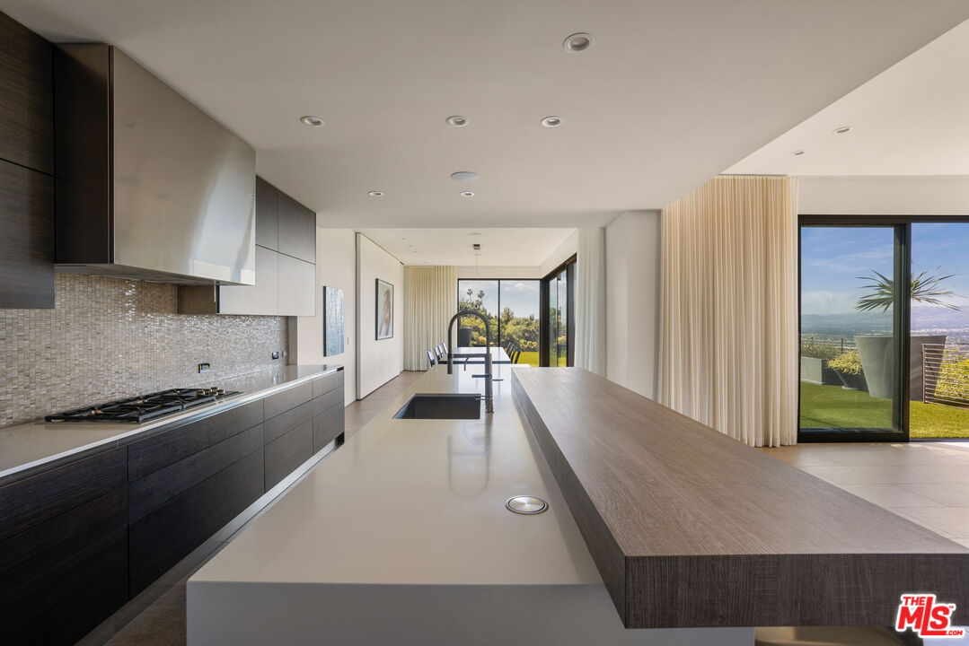 3337 Beverly Ranch Road Beverly Hills, CA 90210 - Photo 11 of 36 a large kitchen with kitchen island a large counter top space a sink stainless steel appliances and cabinets