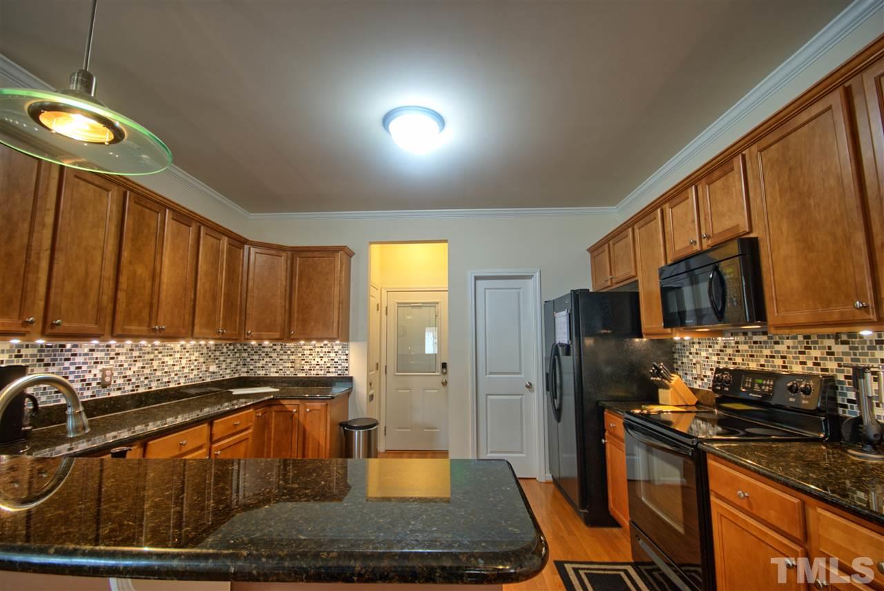 4904 Jelynn Street Raleigh, NC 27616 - Photo 8 of 25 Kitchen with Walk in Pantry features Granite Counters. tile back splash and under cabinet lighting. Plenty of storage.