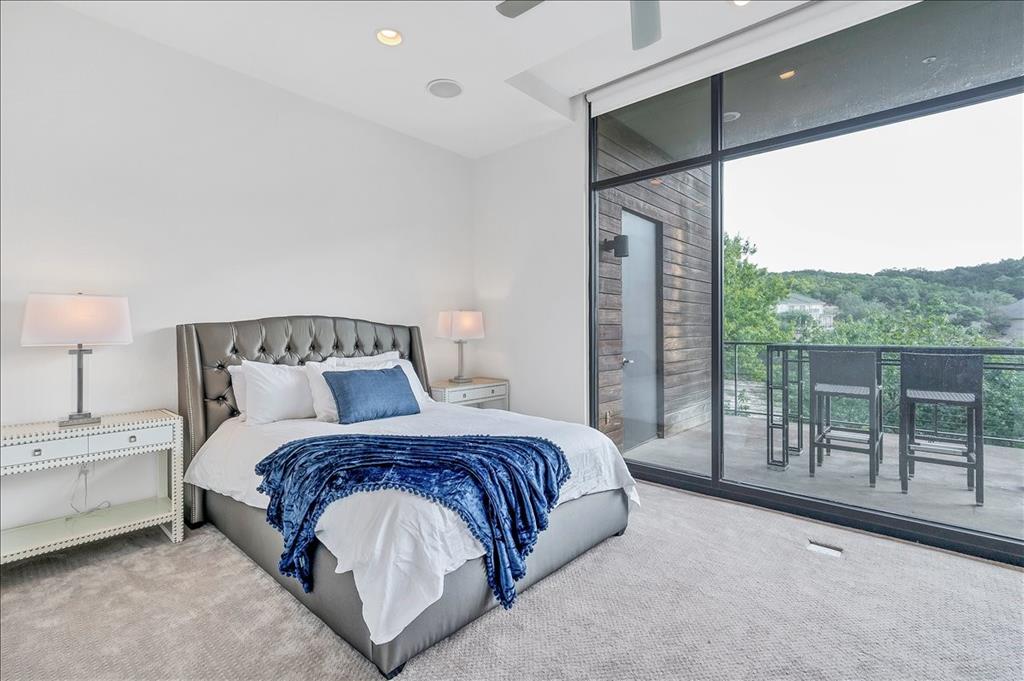 1101 Ivean Pearson Road, Unit A102 Lago Vista, TX 78645 - Photo 12 of 31 Bedroom with access to exterior, a wall of windows, carpet, recessed lighting, and ceiling fan