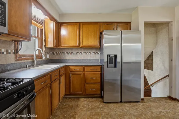 a kitchen with stainless steel appliances granite countertop a refrigerator and a sink