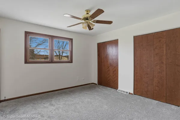 a view of an empty room with a ceiling fan