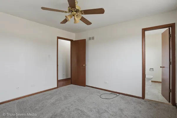 a view of an empty room and a fan