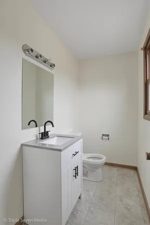 a bathroom with a toilet a sink and mirror