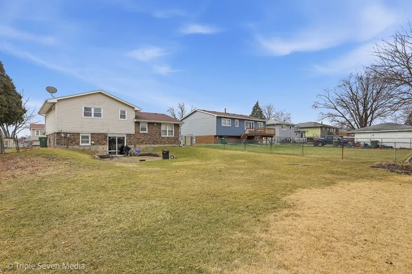 a view of a house with a big yard and a large tree