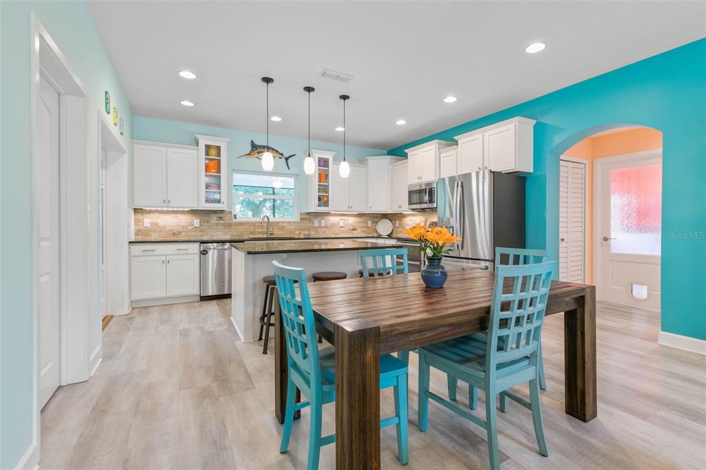 47 Sandy Beach Way Palm Coast, FL 32137 - Photo 15 of 70 a kitchen with stainless steel appliances granite countertop a table chairs wooden floors and a view of living room