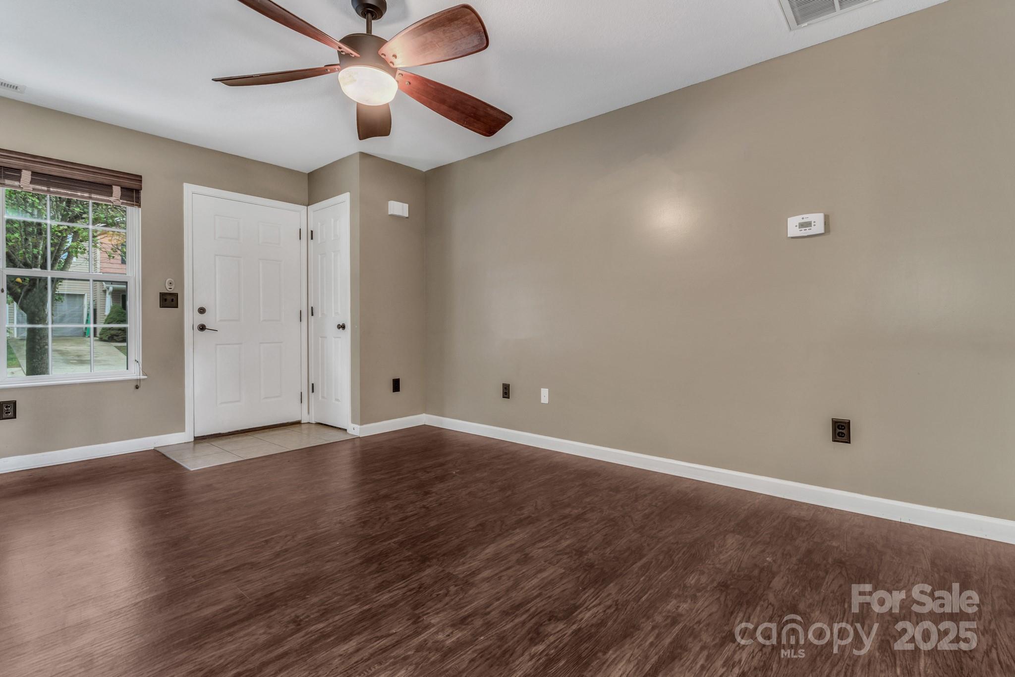 4 Lilac Fields Way Arden, NC 28704 - Photo 11 of 33 an empty room with wooden floor chandelier fan and windows