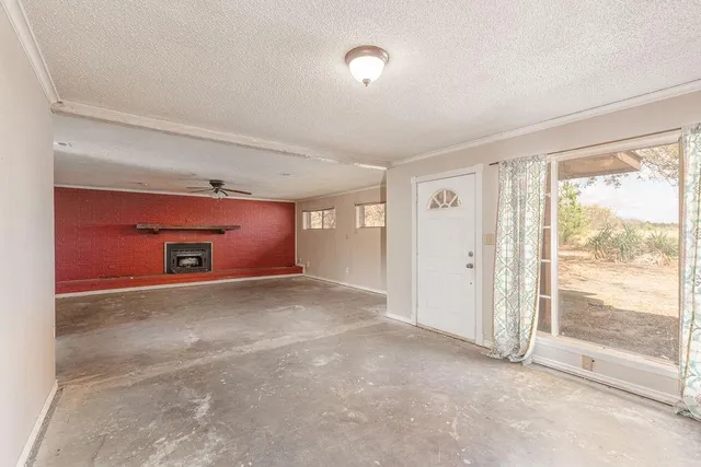 an empty room with a fireplace and fan
