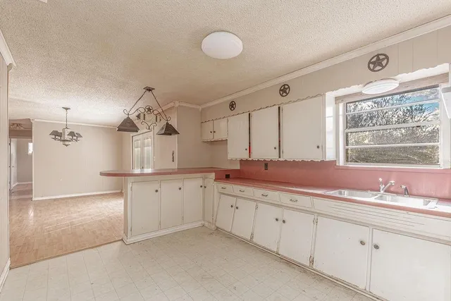 a kitchen with stainless steel appliances granite countertop a sink a stove a refrigerator cabinets and chairs