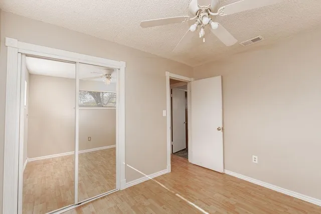 an empty room with windows and fan