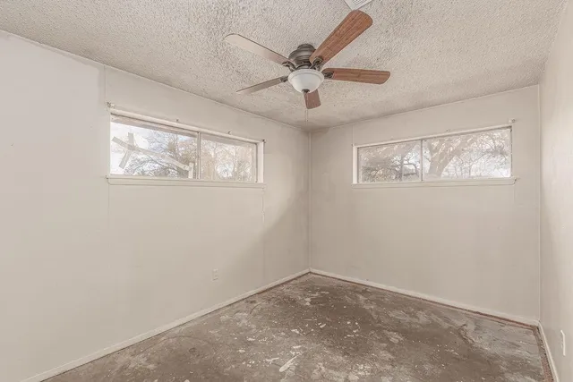 a view of a room with a ceiling fan and closet area