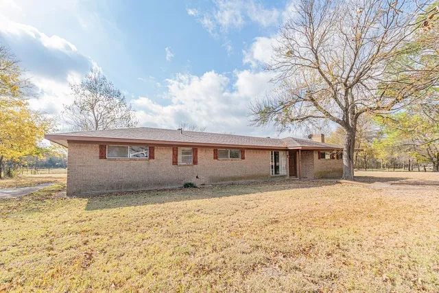 a front view of house with yard and trees