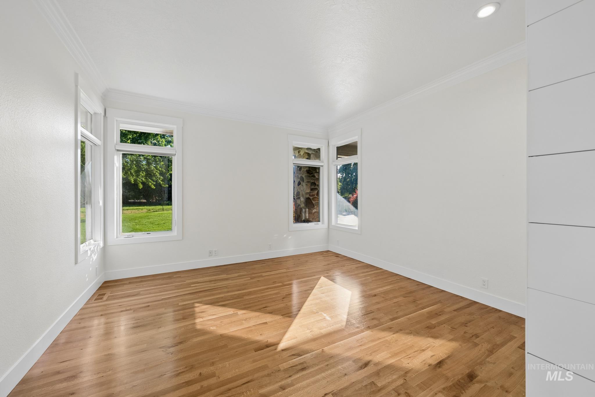 2050 Artesian Road Eagle, ID 83616 - Photo 35 of 49 Hallway featuring wood-finish flooring, white baseboards, and a bi-fold panel door closet with black hardware