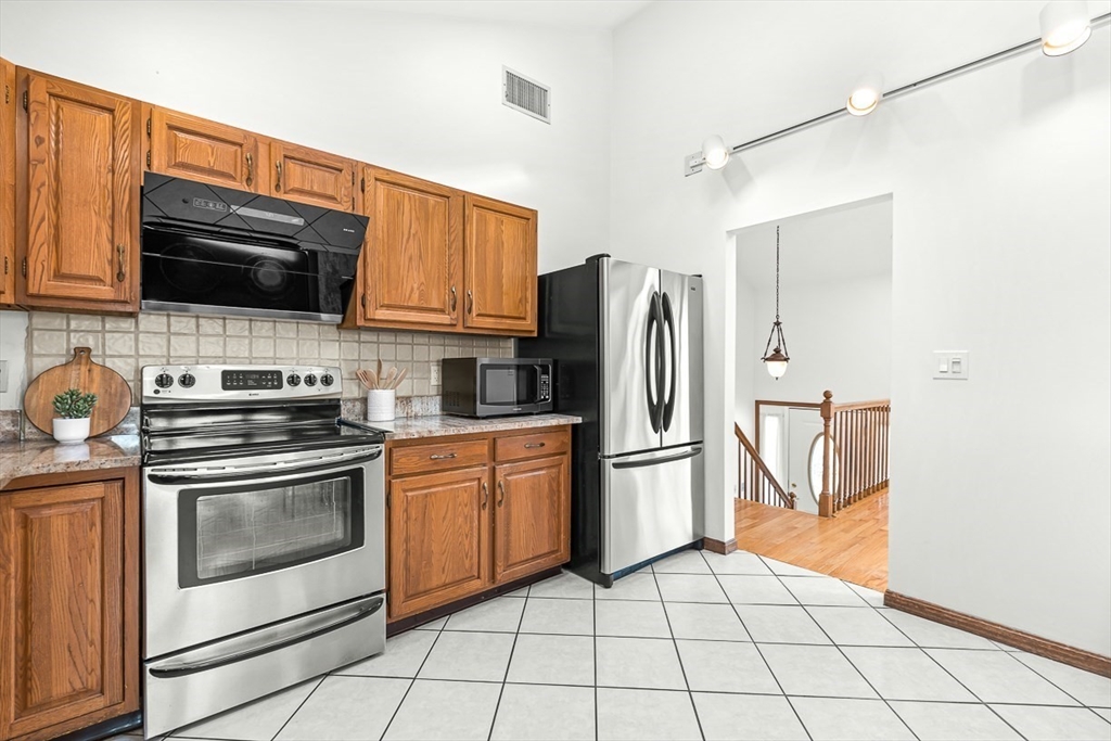 25 Murdoch Road Stoneham, MA 02180 - Photo 13 of 39 a kitchen with stainless steel appliances granite countertop a stove a refrigerator and a microwave