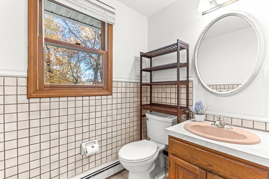 25 Murdoch Road Stoneham, MA 02180 - Photo 15 of 39 a bathroom with a sink a toilet a mirror and a window