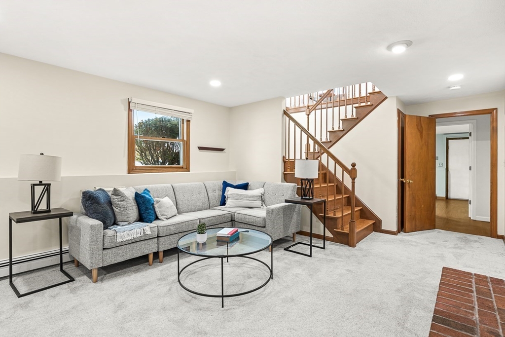 25 Murdoch Road Stoneham, MA 02180 - Photo 27 of 39 a living room with furniture and a dining table with wooden floor