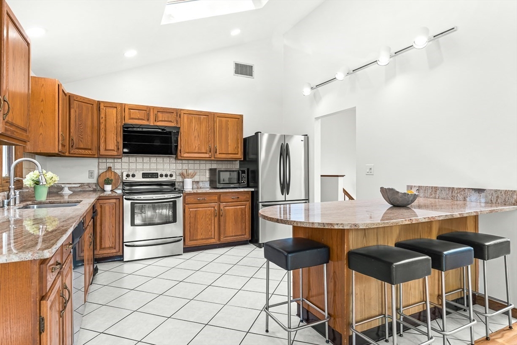 25 Murdoch Road Stoneham, MA 02180 - Photo 10 of 39 a kitchen with stainless steel appliances a stove a sink island and a refrigerator
