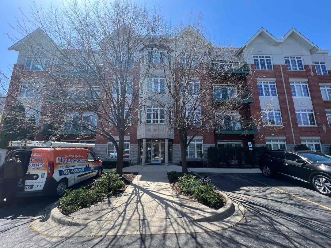 a view of a brick house with many windows yard and large tree