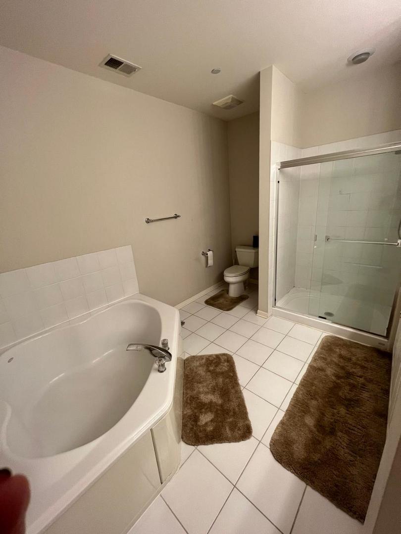 660 McHenry Road, Unit 107 Wheeling, IL 60090 - Photo 12 of 24 a bathroom with a bathtub and a shower