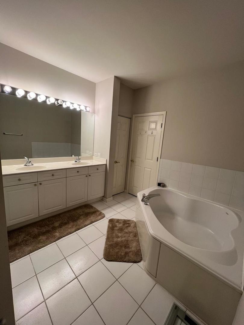 660 McHenry Road, Unit 107 Wheeling, IL 60090 - Photo 13 of 24 a bathroom with a tub sink and mirror