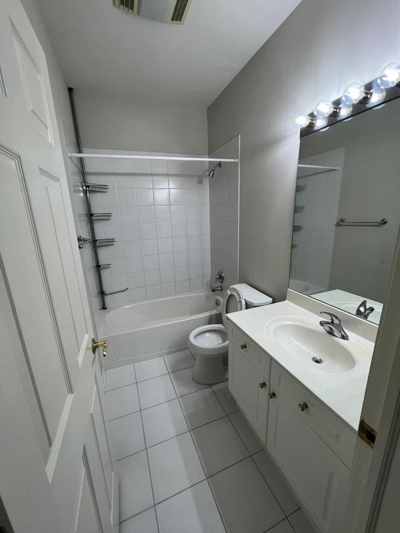660 McHenry Road, Unit 107 Wheeling, IL 60090 - Photo 14 of 24 a bathroom with a sink a toilet and shower