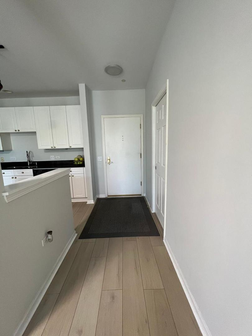 660 McHenry Road, Unit 107 Wheeling, IL 60090 - Photo 5 of 24 a view of a kitchen with white cabinets and black appliances