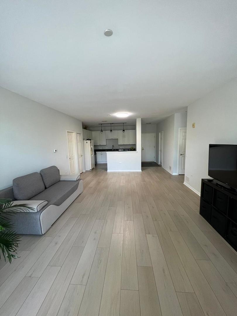 660 McHenry Road, Unit 107 Wheeling, IL 60090 - Photo 9 of 24 a living room with furniture and a flat screen tv