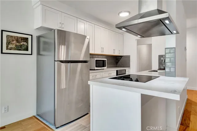 a kitchen with stainless steel appliances a refrigerator sink and microwave