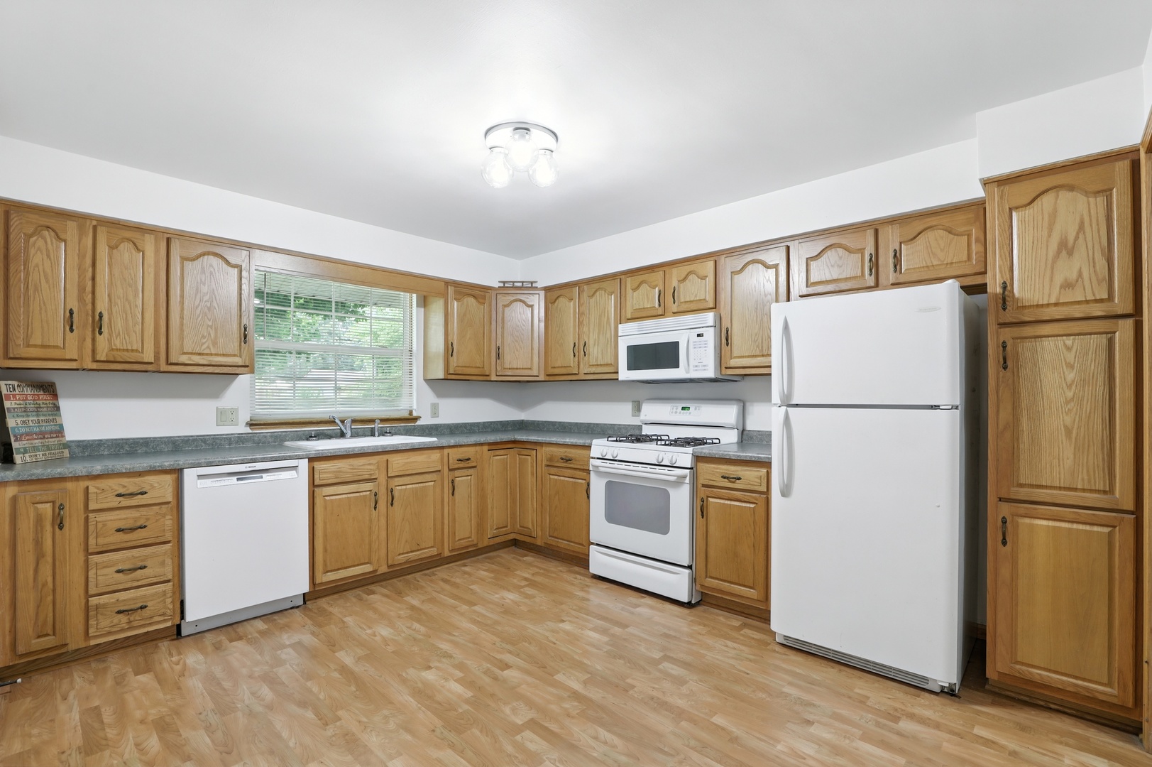 1401 20th Street Zion, IL 60099 - Photo 9 of 30 a kitchen with granite countertop appliances a sink cabinets and a window