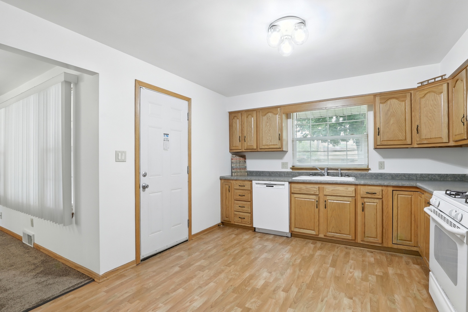 1401 20th Street Zion, IL 60099 - Photo 10 of 30 a large kitchen with granite countertop a stove a sink dishwasher and a refrigerator