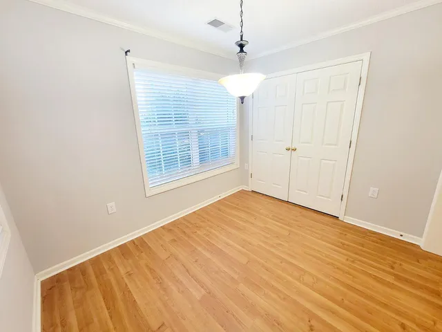 a view of a room with wooden floor and white walls