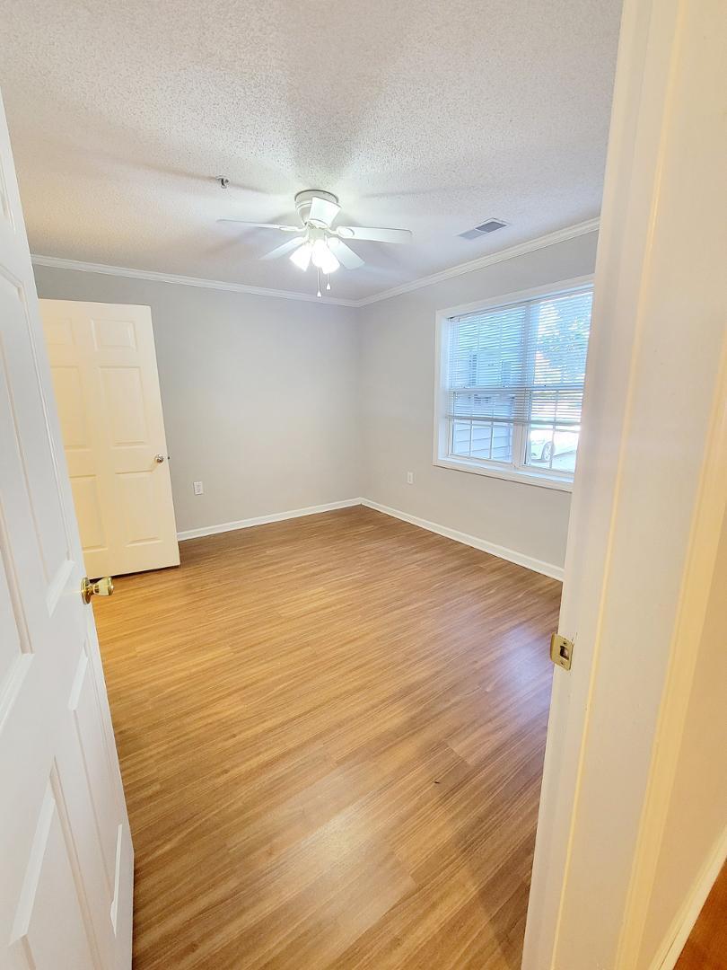 3770 Pardue Woods Place, Unit 103 Raleigh, NC 27603 - Photo 24 of 42 a view of an empty room with wooden floor and a window